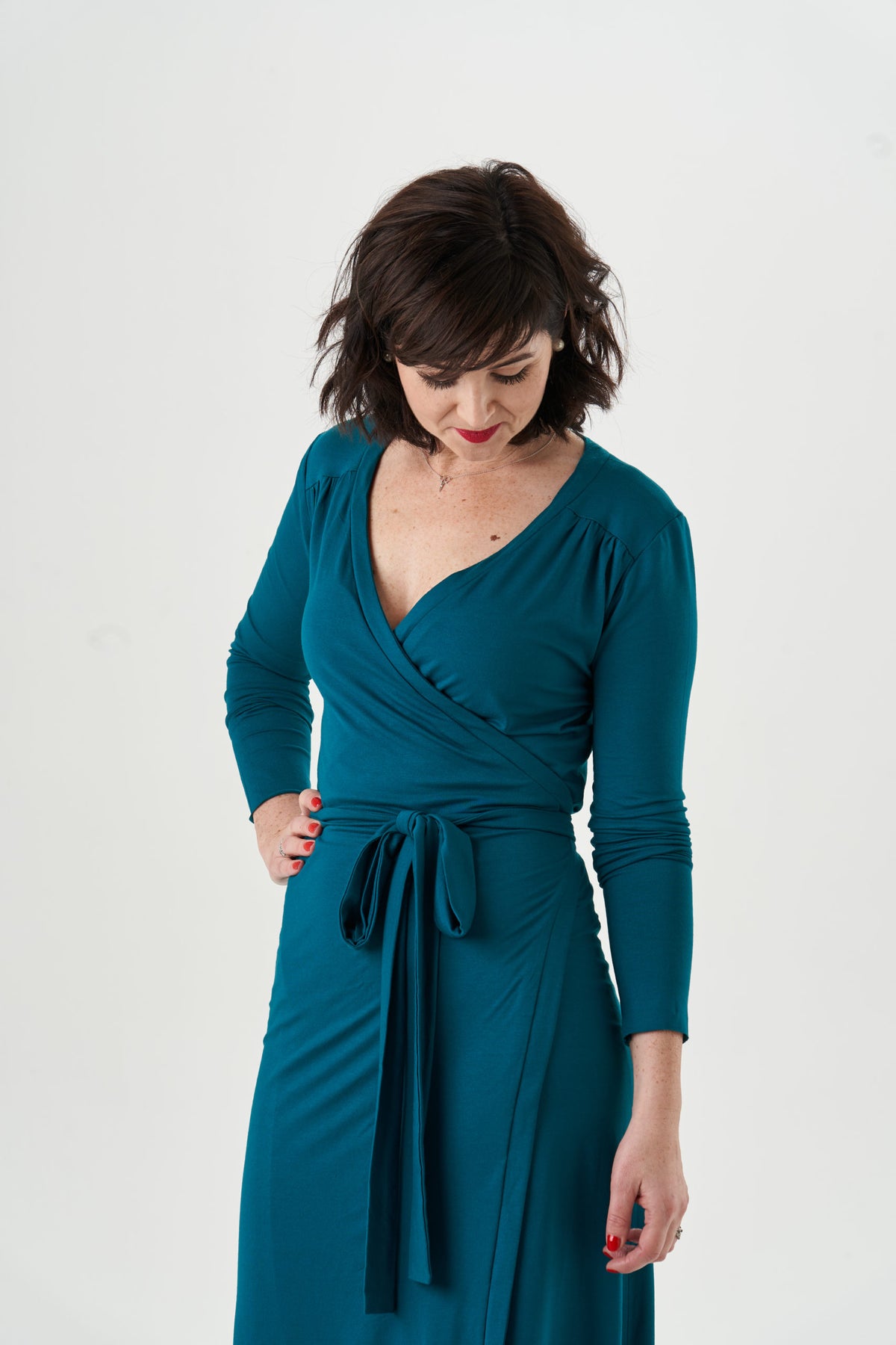 Garment reference: teal jersey wrap dress showing the overlapping neckline, gathered shoulder yokes and long waist ties